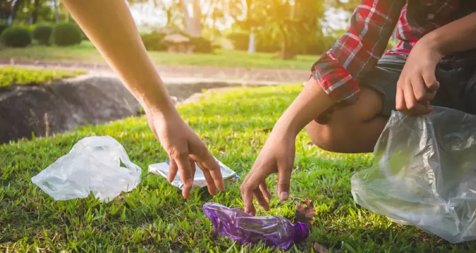 Zwei Menschen, die Plastik für Recycling aufsammeln